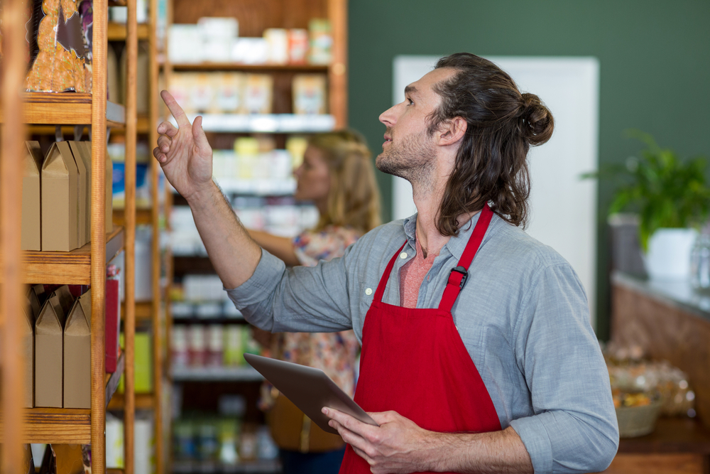 Staff member checking products on a store shelf